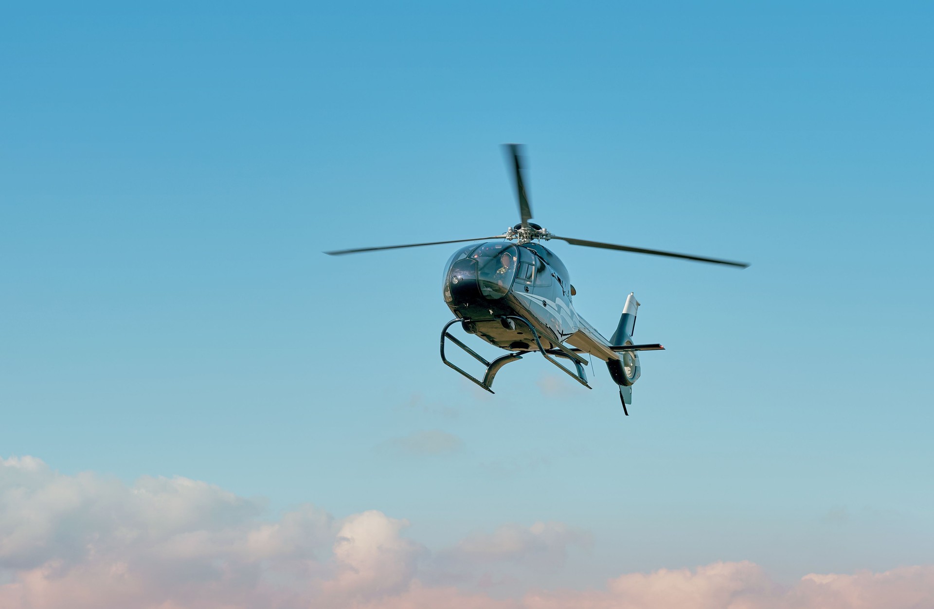 Helicopter flying in the sky against a clear blue backdrop